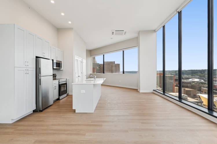 Cincinnati apartments for rent - image - A modern kitchen with wooden floors and a large window overlooking the city.