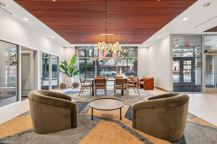 Cincinnati apartments for rent - image - A modern waiting room with brown chairs and a round table.
