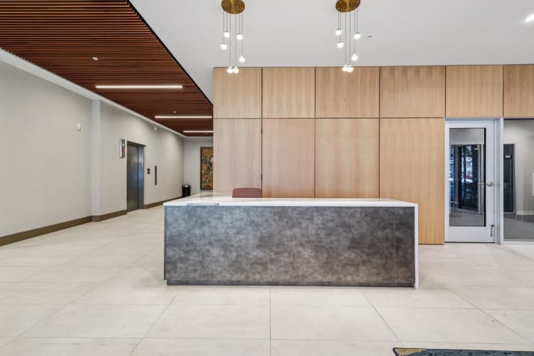 Cincinnati apartments for rent - image - A reception area with a concrete counter and wooden panels on the wall.