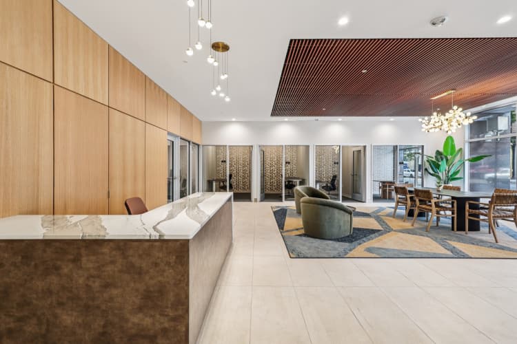 Cincinnati apartments for rent - image - A modern office lobby with a reception desk and seating area.