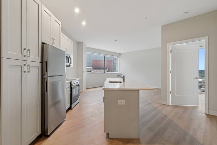Cincinnati apartments for rent - image - A kitchen with a refrigerator, sink, and cabinets.