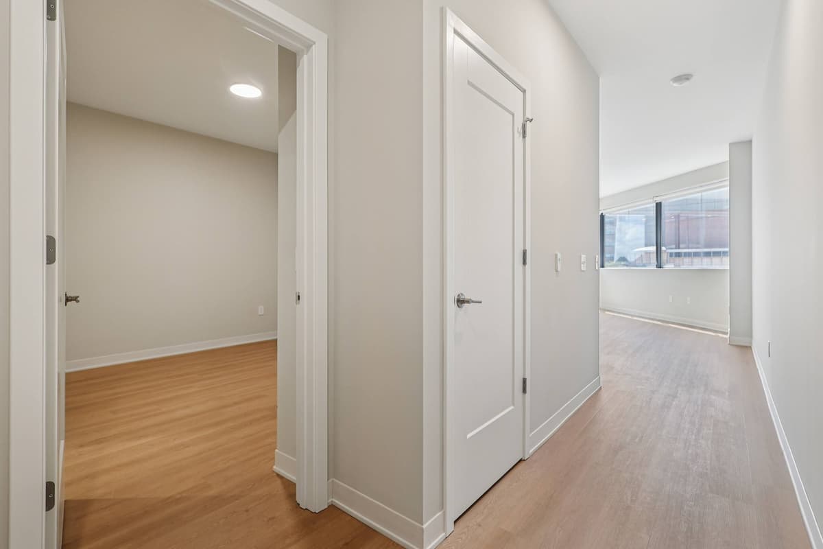 Cincinnati apartments for rent - image - A long hallway with white doors and wood floors.