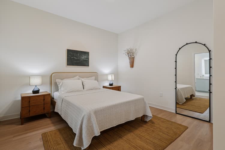 Cincinnati apartments for rent - image - A bedroom with a bed, nightstands, and a mirror.