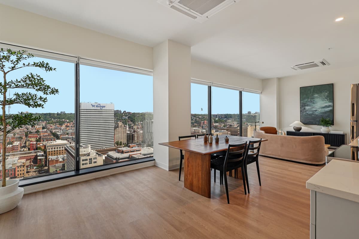 undefined apartments for rent - image - A room with a table and chairs in front of a window with a view of a city.