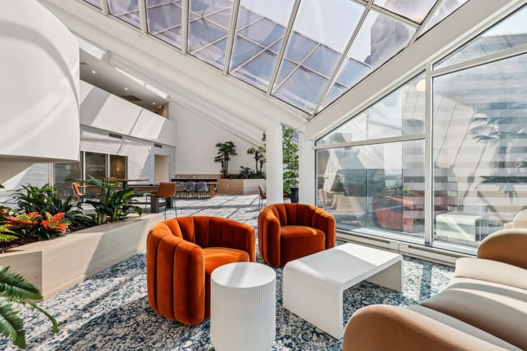 undefined apartments for rent - image - A modern living room with a glass ceiling and a variety of seating options.