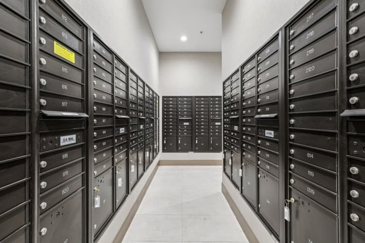 undefined apartments for rent - image - A long hallway of black mailboxes with numbers on them.