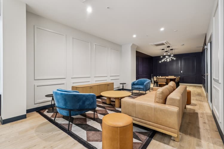 undefined apartments for rent - image - A living room with a blue chair and a tan couch.