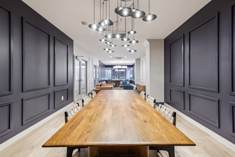 undefined apartments for rent - image - A long wooden table is surrounded by grey panels on the wall.