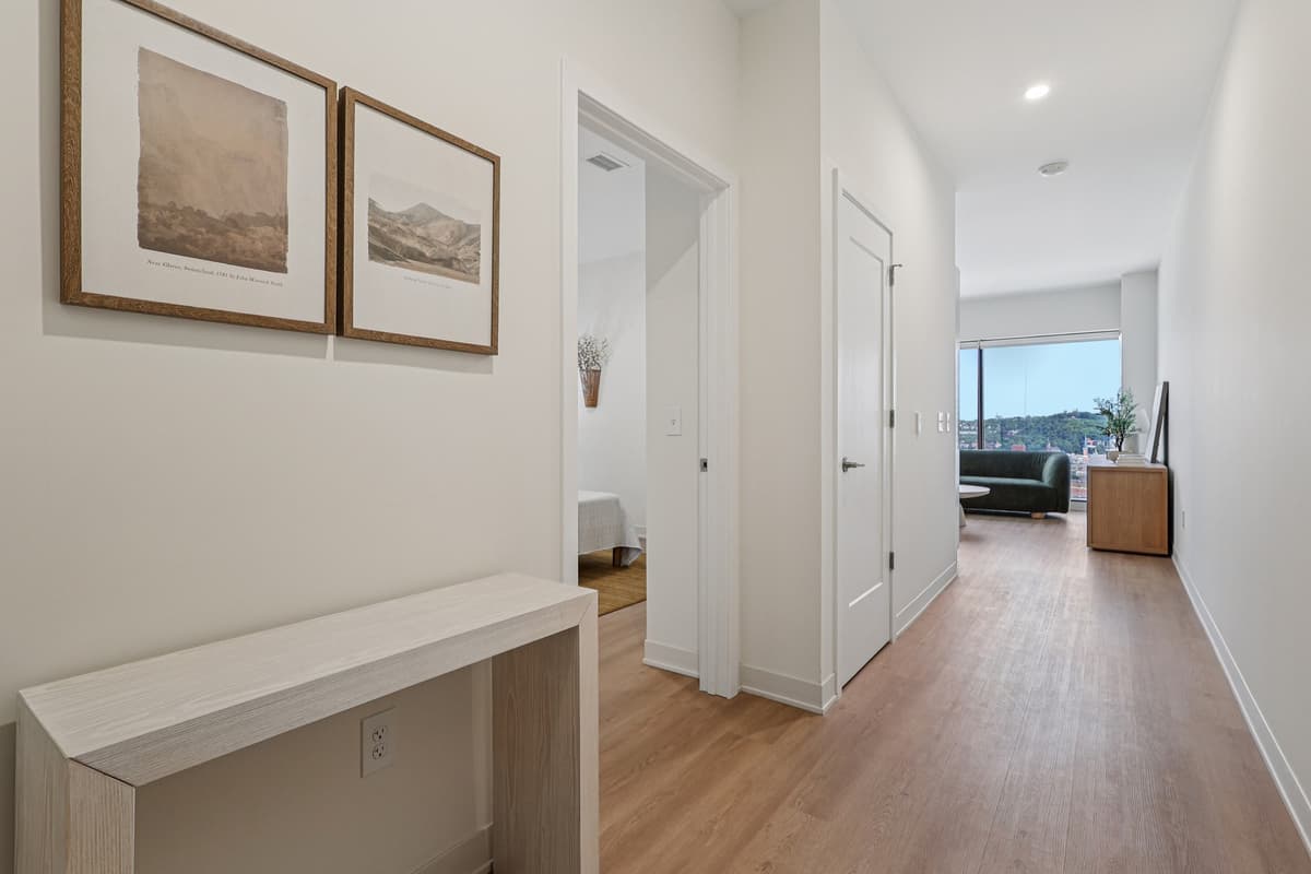 undefined apartments for rent - image - A long hallway with a bench and pictures on the wall.