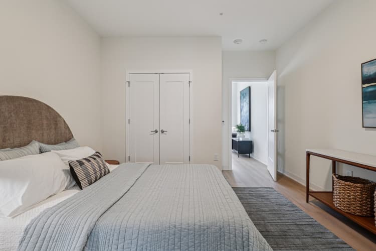 undefined apartments for rent - image - A bedroom with a large bed and a painting on the wall.