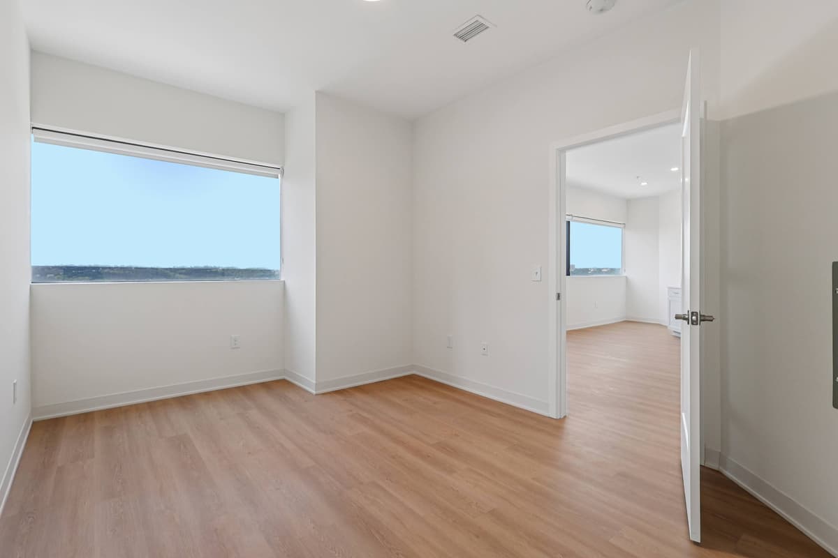 undefined apartments for rent - image - A room with a wooden floor and white walls.