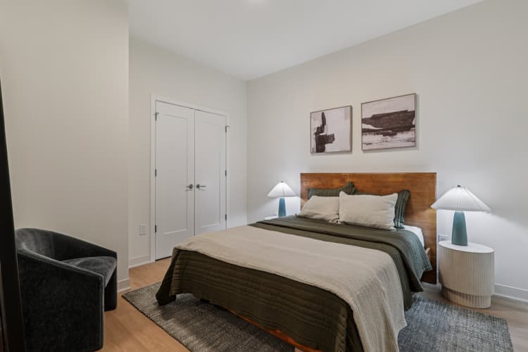 undefined apartments for rent - image - A bedroom with a large bed and two lamps.