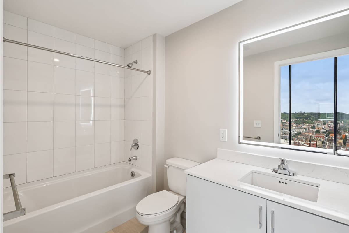 undefined apartments for rent - image - A white bathroom with a toilet, sink, and tub.